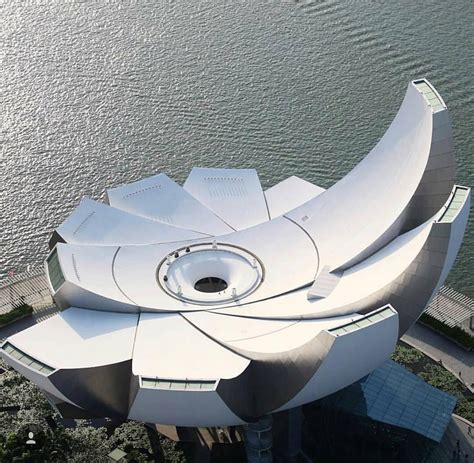 an aerial view of a futuristic building near the water