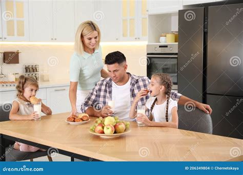 Happy Family Eating Together at Table in Modern Kitchen Stock Photo - Image of happy, kids ...