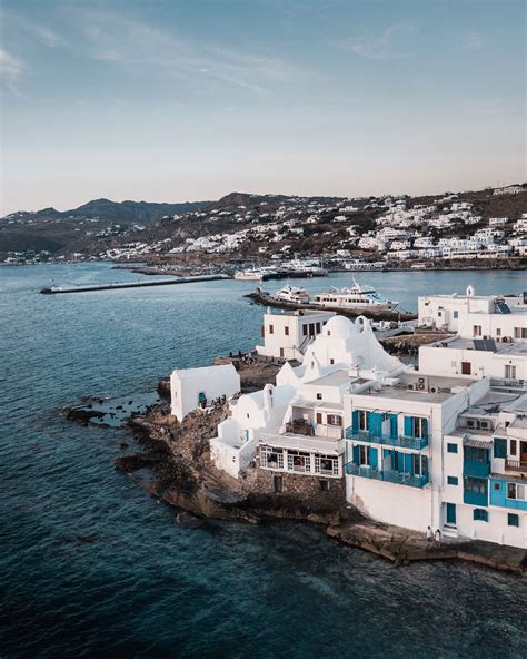 The white-washed buildings in Chora stand out against the rocky shoreline. Mykonos Island Greece ...