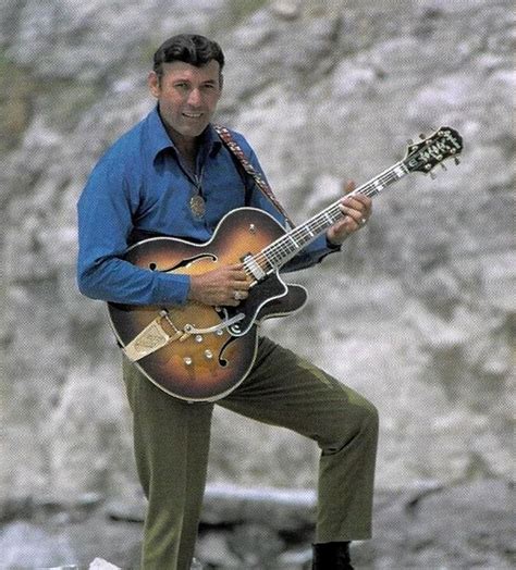 a man playing an electric guitar in front of a rock face with the caption's name on it