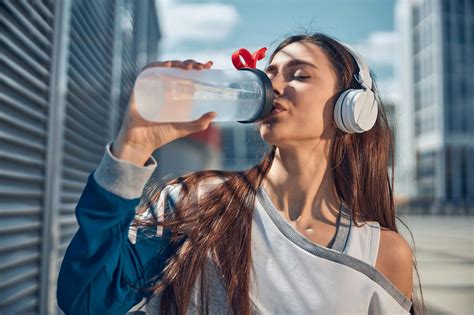 Woman in White Shirt Drinking Water · Free Stock Photo