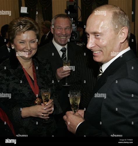 Russian President Vladimir Putin (R) holds a glass of wine after award ...