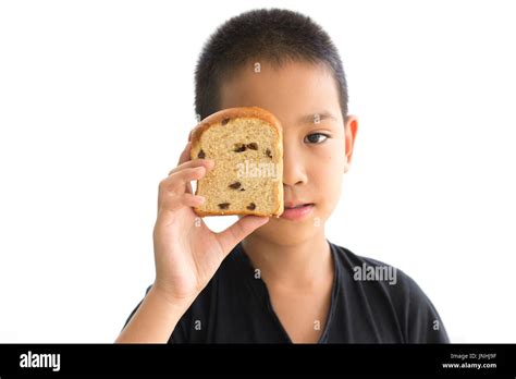 Asian boy shutting eyes with whole wheat raisin loaf bread isolated on white background Stock ...