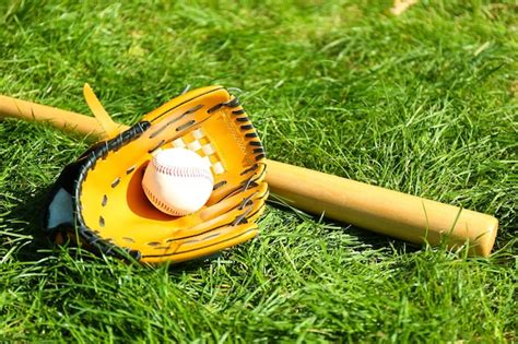 Premium Photo | Baseball bat ball and glove on green grass background