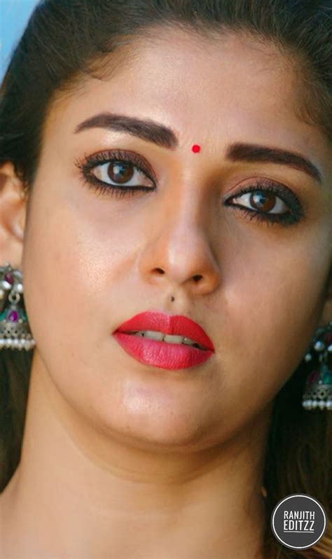 a close up of a woman with red lipstick and large earrings on her head ...