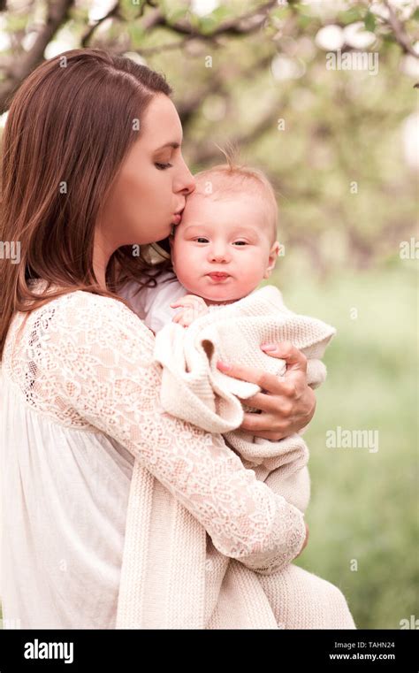 Mother holding baby posing outdoor over green nature background Stock Photo - Alamy