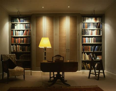 a room filled with lots of books next to a desk and chair in front of a ...