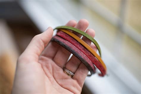 Close-up of Human Hand Holding Multi Colored Bracelets · Free Stock Photo