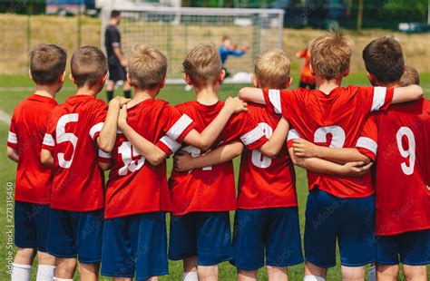 Youth european football team in red shirts. Young boys of soccer club on the stadium during ...