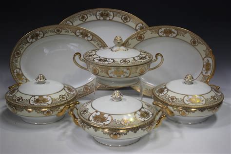 A Noritake porcelain part service, decorated in gilt with baskets of ...