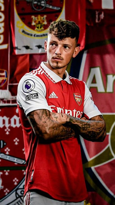 a man with tattoos standing in front of some red and white banners on ...