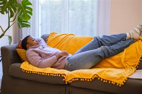 Premium Photo | Young woman with short curly hair napping on the sofa ...