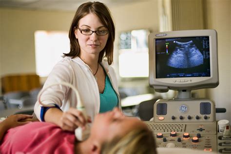 Nurse doing ultrasound on thyroid. | Scott Dobry Pictures