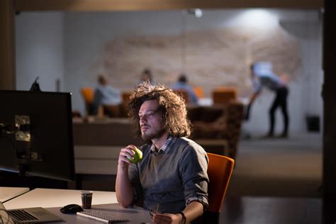 man working on computer in dark office 12437721 Stock Photo at Vecteezy