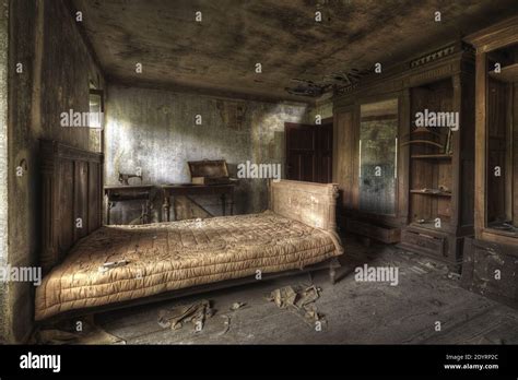 A bedroom of an abandoned house with dirty walls and broken furniture ...