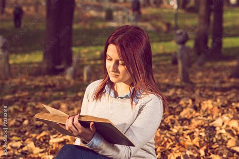 Girl sitting on bench in ark and reading a book Stock Photo | Adobe Stock