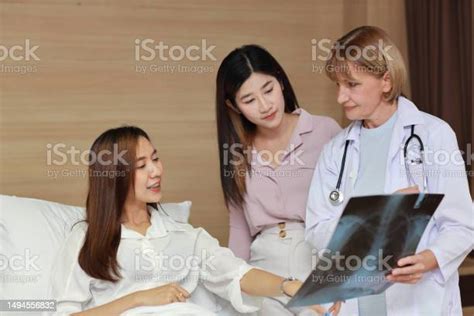 Female Doctor Greeting And Showing Happy Patient And Her Friend With ...