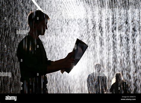 People interact with the 'Rain Room' art installation by 'Random ...