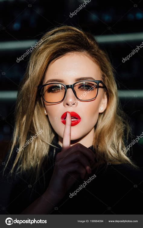 Hush. Woman in glasses ask for silence or secrecy with finger on red lips. shh hand gesture ...