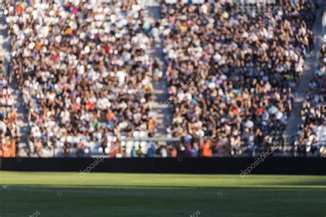 Multitud borrosa de espectadores en un tribuno del estadio en un e ...