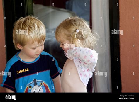 zwei, 3 Jahre alte Kinder zusammen Shes heben Sie ihr Oberteil und zeigt ihm ihren Bauch ...