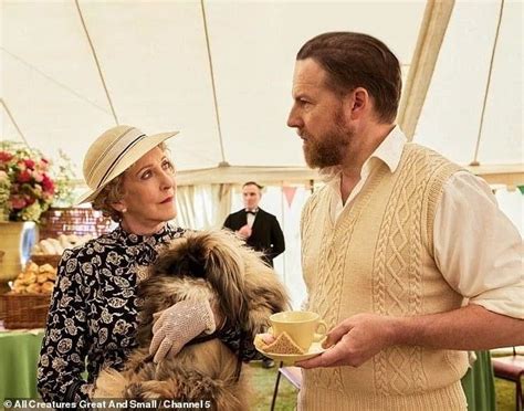 a man and woman standing next to each other with a dog in front of them