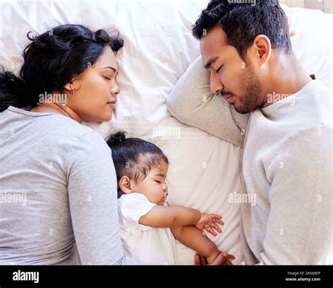 Young family sleeping together from above. Two parents sleeping with ...