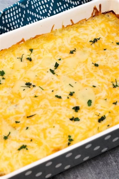 a casserole dish with cheese and parsley in it on a blue towel