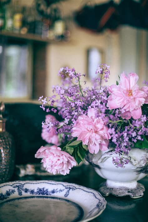 Bright pink peonies in vase near ornamental plate on table · Free Stock Photo