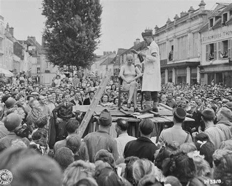 A member of the French resistance publicly shears the hair of a woman who consorted with the ...