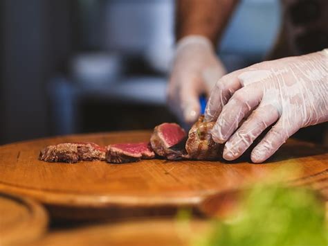 Premium Photo | A chef cutting a fresh beef steak in the kitchen