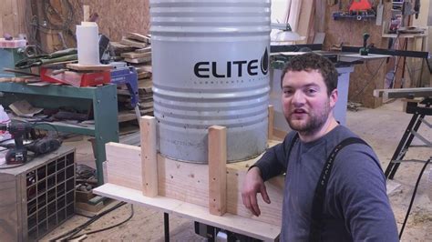 a man standing next to a large metal barrel