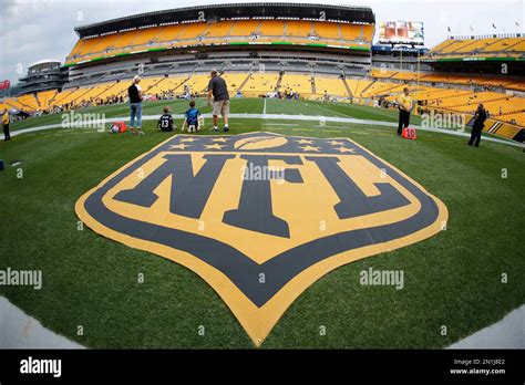 Gold NFL logos are on the sideline during warmup before an NFL football preseason game between ...