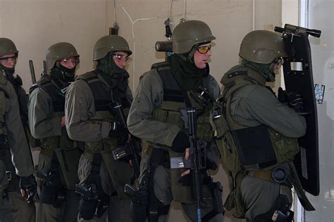 A US Marine Corps (USMC) Special Reaction Team (SRT) prepares to charge into a room to rescue ...