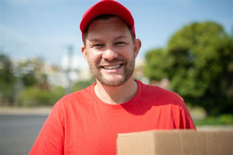 Close-Up Shot of a Deliveryman Holding a Box · Free Stock Photo