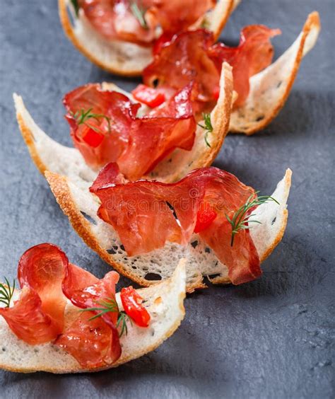 Appetizer Bruschetta With Jerky Prosciutto On Thinly Sliced Ciabatta Bread On Stone Slate ...