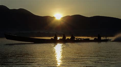 Longboats on Inle Lake at sunrise - Travel Badger