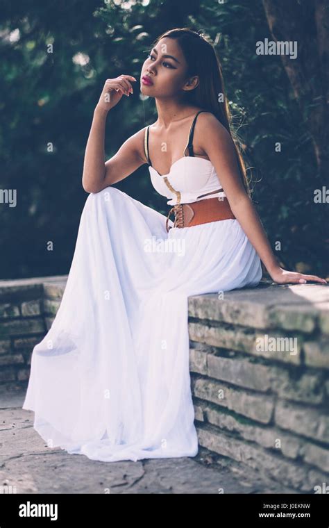 Beautifull girl in long white dress sitting, posing in the park Stock Photo - Alamy