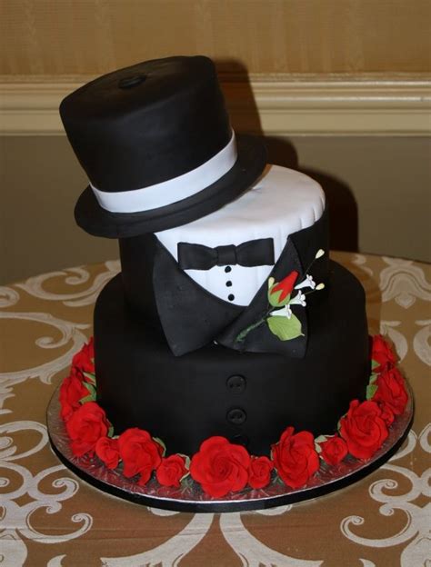 a three tiered cake with a top hat and bow tie on it's side