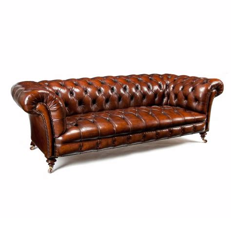 a brown leather couch sitting on top of a white floor