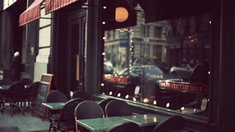 tables and chairs in front of a window with a traffic light on the side ...