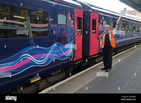 Station manager signaling train departure on Platform at Swansea ...