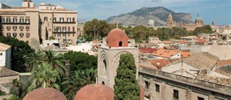 an old city with lots of buildings and mountains in the background