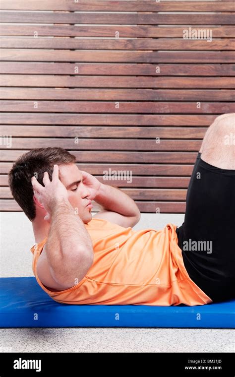 Man doing sit-ups in a gym Stock Photo - Alamy