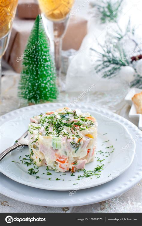 Traditional Russian Christmas Salad "Olivier" on a white plate in the ...