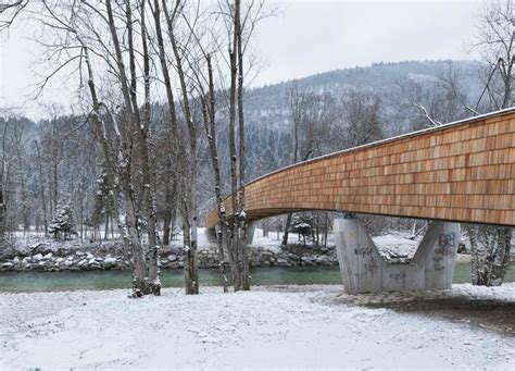 Architects create beautiful arched footbridge out of timber planks and shingles DANS Architects ...