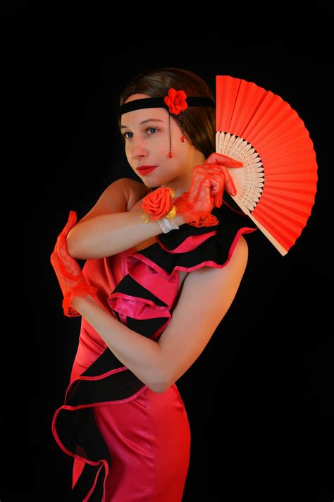 Flamenco dancer in bright costume standing against black background · Free Stock Photo