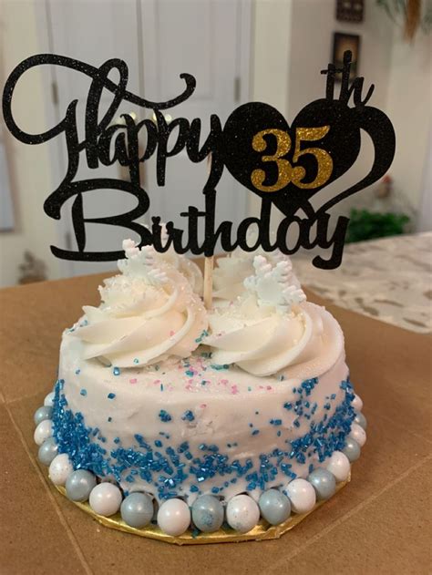 a birthday cake with white frosting and blue sprinkles