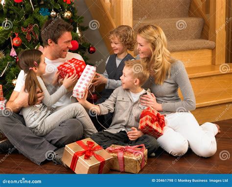 Family Exchanging Gifts in Front of Christmas Tree Stock Photo - Image ...