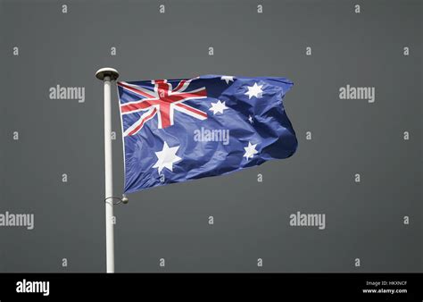 The australian flag, Commonwealth Blue Ensign, in front of a dark sky Stock Photo - Alamy